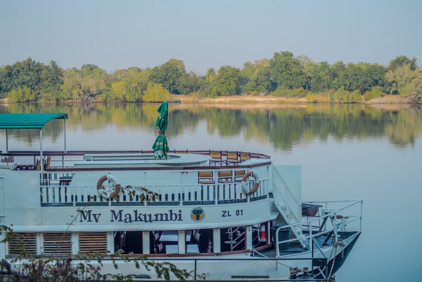 A large white boat floating on top of a lake